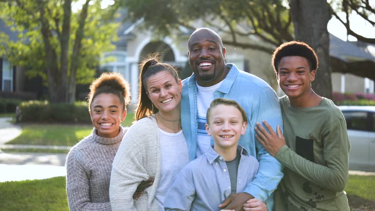 Blended multi-ethnic family, gathers for photo in yard