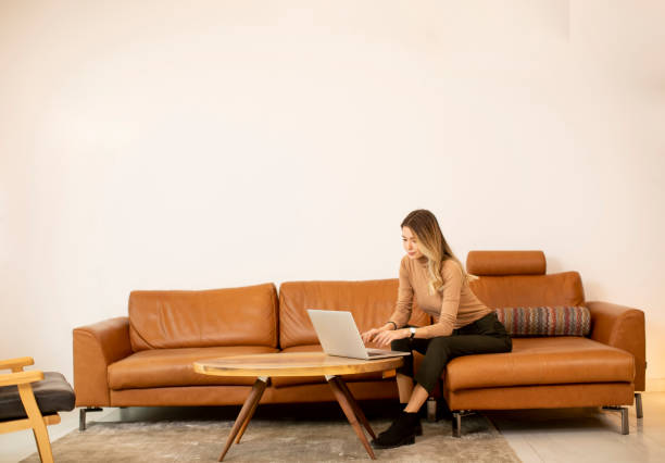 istock Young beautiful woman using a laptop at home 1335814565