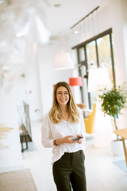 istock Smiling young businesswoman using mobile phone in the office 1335814568
