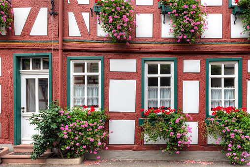 the façade of a half-timbered house with ornamental flowers