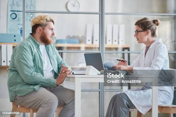 Man Talking To The Doctor At Office Stock Photo - Download Image Now - Overweight, Patient, Doctor