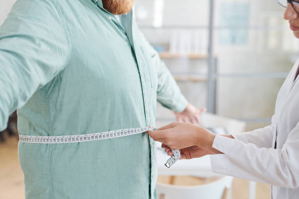 istock Doctor measuring obese man stomach 1335814916