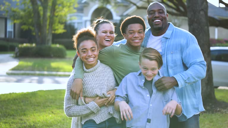 Blended multi-ethnic family, gathers for photo in yard