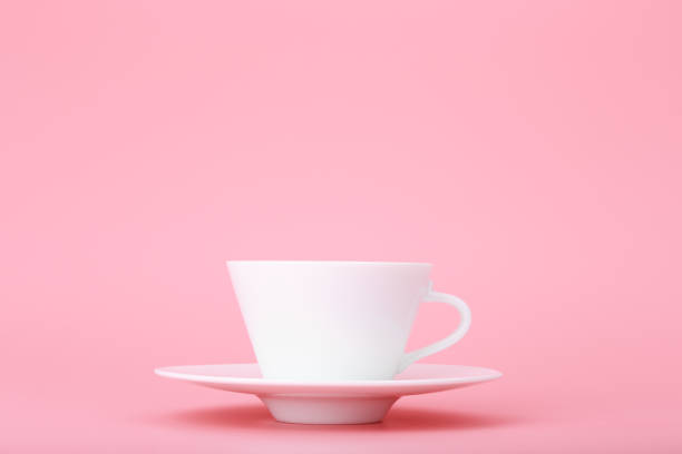 istock Close up of white ceramic coffee or tea cup isolated on bright pink background 1335830406