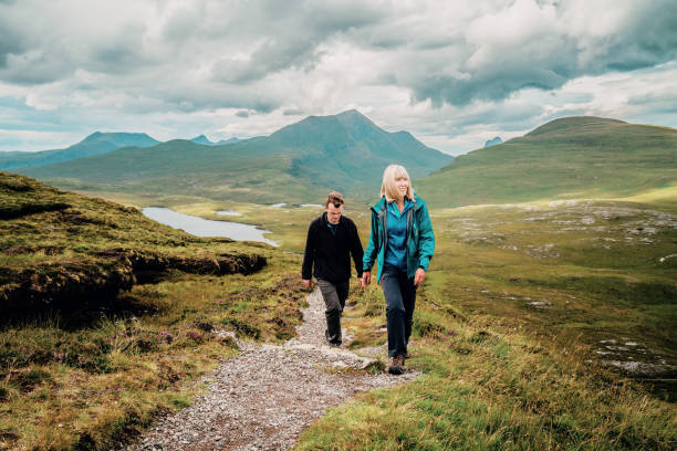 Hiking trail in Scotland Mature woman and her adult son on the Knockan Crag trail above the Geopark between Ullapool and Elphin in the Assynt region of the Scottish Highlands. scottish highlands photos stock pictures, royalty-free photos & images