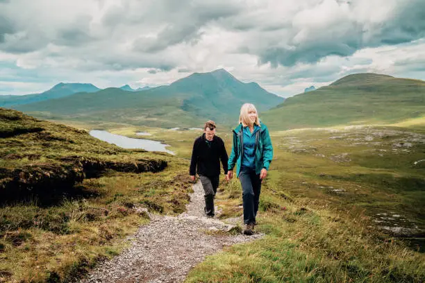 Mature woman and her adult son on the Knockan Crag trail above the Geopark between Ullapool and Elphin in the Assynt region of the Scottish Highlands.