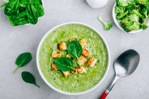 Green Cream Soup. Spinach broccoli creamy soup with croutons on gray stone background. Green Cream Soup. Spinach broccoli creamy soup with croutons on gray stone background. Top view with copy space. cream soup stock pictures, royalty-free photos & images