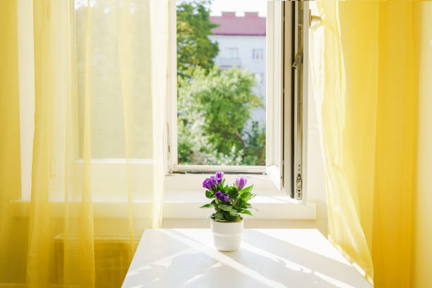 Room with big window and bright yellow curtains. Positive colors. Illuminating yellow. Stress reducing concept. Comfort zone. Interiors