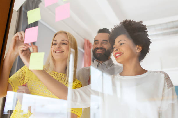 istock happy creative team writing on stickers at office 1335836604