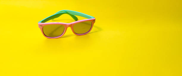 istock Sunglasses, Two-tone glasses, with a purple front frame and a turquoise stem on a yellow background. Radiation shielding glasses. 1335836781