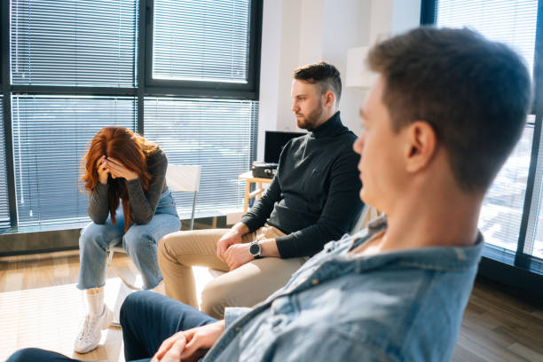 istock Sad crying young woman sharing mental problem to other patients sitting in circle during group therapy session. 1335839758
