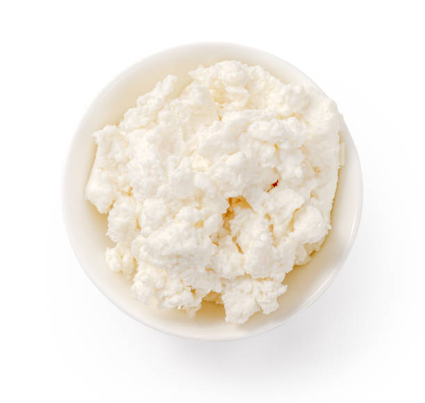 Fresh ricotta cheese in white bowl isolated. Ricotta soft cheese on white background. Cheese for package design. stock photo