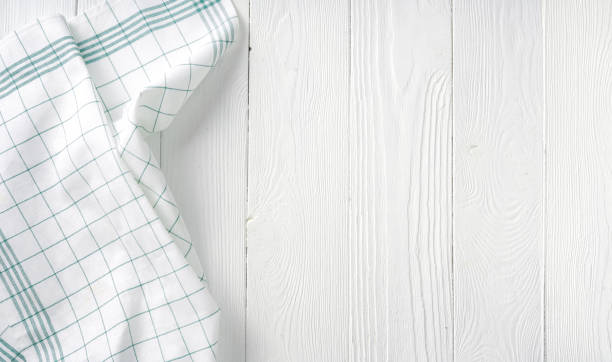 istock Kitchen dish towel on white table with copy space. Kitchen napkin on white background. Check pattern towel. 1335840129