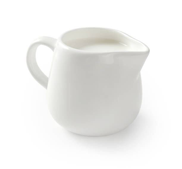 istock Ceramic milk jar isolated on white background. Milk pitcher for package design. Porcelain creamer pitcher with milk on white. 1335840208