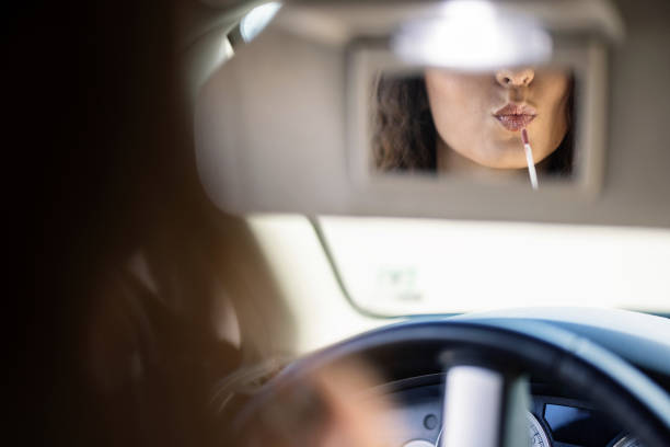 Woman fixing her makeup in the car
