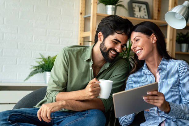 istock In love couple using a tablet computer in their living room. Free time together. 1335847963