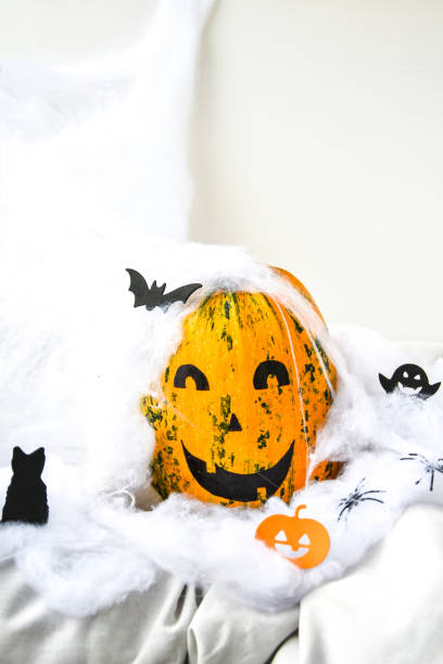 тыква с нарисованным лицом на цветном фоне к хэллоуину. паутина. праздничные украшения - jack fruit стоковые фото и изображения