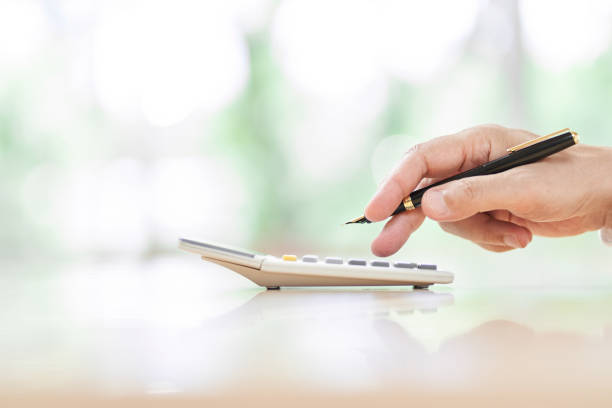 Hands of elderly people doing calculations with a calculator Hands of elderly people doing calculations with a calculator working seniors stock pictures, royalty-free photos & images