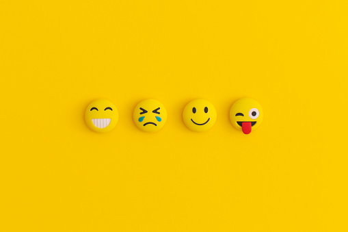 3d rendering of tears of joy emoji with smiley face on blue background.