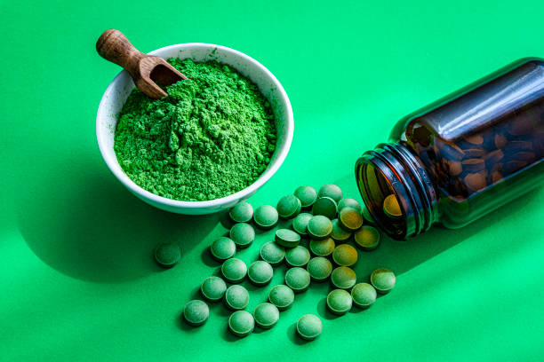 istock Moringa oleifera pills and powder shot on green background 1335854876