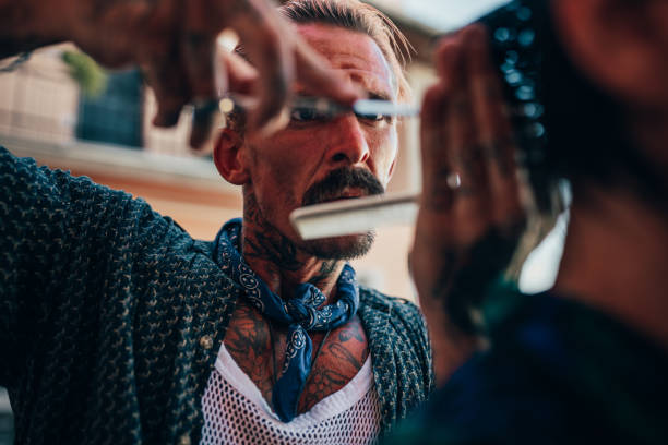 Close up of tattooed hairdresser working Close up of middle age tattooed hairdresser cutting hair chest tattoos for men designs stock pictures, royalty-free photos & images