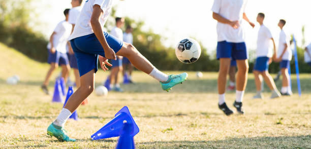 adolescentes pasa pelota de fútbol entre sí en el campo de fútbol. - pass the ball fotografías e imágenes de stock