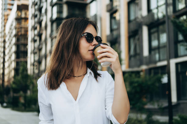 istock Woman holding coffee in paper cup 1335857840