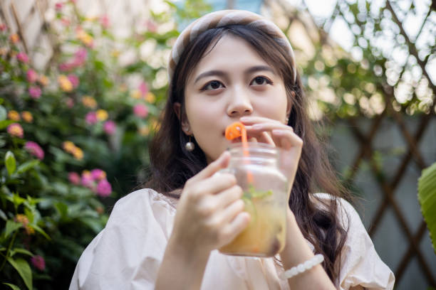 istock Young women drinking  juice outdoor 1335860282