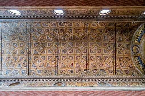 Intricate Persian architecture inside Chehel Sotun Palace. Reflective stone flooring and detailed ceiling patterns, Isfahan, Iran.