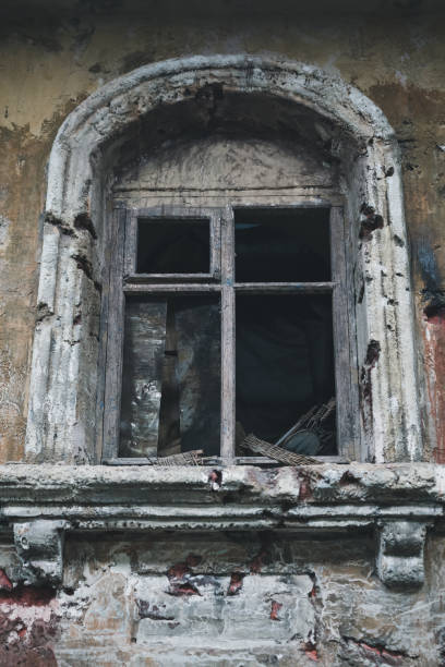 istock vertical view of broken scary window of abandoned house 1335861602