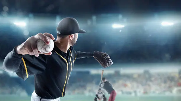 Powerful shot, serve. Professional baseball player in motion, action during match at stadium over blue evening sky with spotlights. Concept of movement and action, sport lifestyle, competition