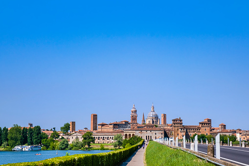 Tourists cycling on the bicycle lane towards the city of Mantua.