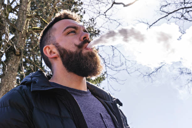 kuvapankkikuvat ja rojaltivapaat kuvat aiheesta parrakkaan miehen muotokuva höyryt ulkona, matalakulmanäkymä - electronic hookah smoke