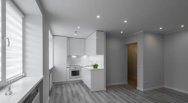 istock Modern interior of luxury studio apartment after renovation. White kitchen with fridge and oven. Living room without furniture. 1335868193