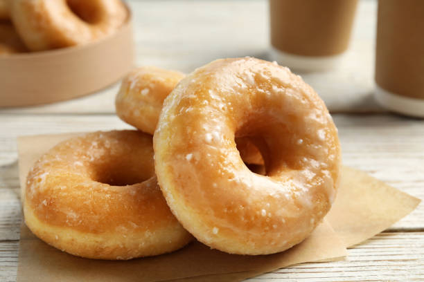 istock Delicious donuts on white wooden table, closeup 1335868312