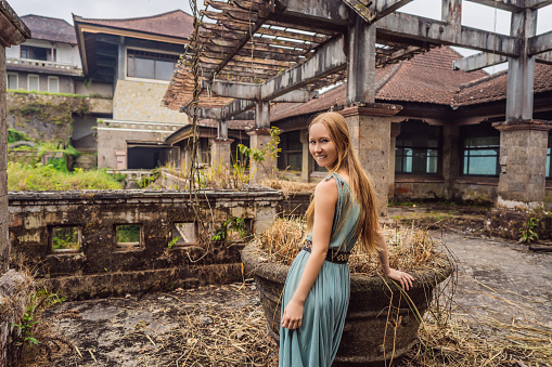 Woman tourist in abandoned and mysterious hotel in Bedugul. Indonesia, Bali Island. Bali Travel Concept.