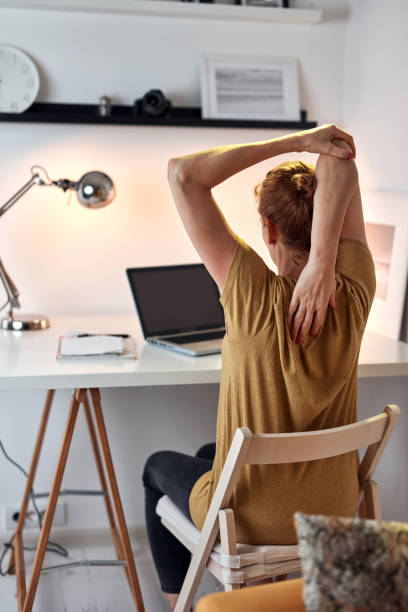 istock Woman working from home on a laptop and stretching arms. 1335870817