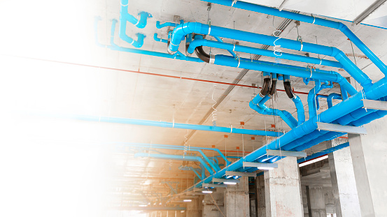 sewer and waste of large blue PVC pipe Inside a high-rise building that can accommodate thousands of residential units. and Copy space in the left-hand side