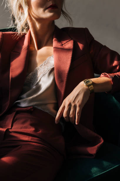 Close up photo of unrecognizable female in red suit sitting on a green armchair