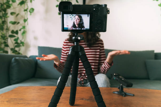 istock Girl video blogging at home. Selective focus on camera. 1335871358