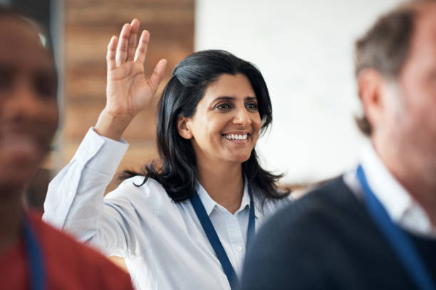 снимок зрелой бизнесвумен, поднимающих руку во время конференции - seminar presentation asking business стоковые фото и изображения
