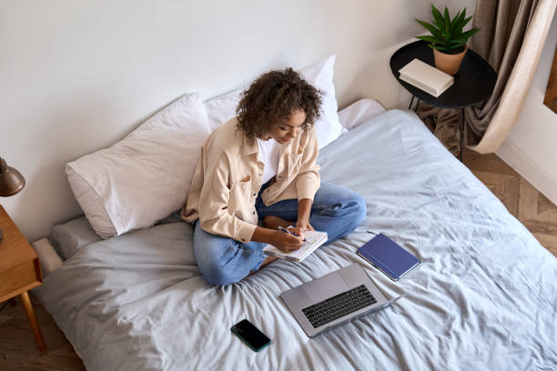 istock African girl student learning online class on laptop watching webinar at home. 1335876747