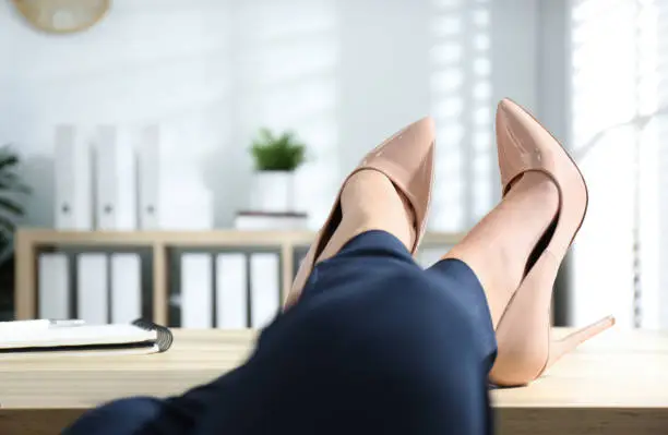 Photo of Lazy worker with feet on desk in office, closeup