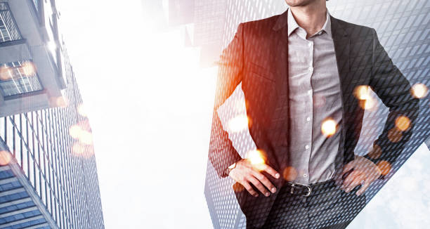 istock Confident businessman with hands on waist, looking for approaches to tasks solutions. Low angle New York panoramic city view at sunset. Business development concept. Double exposure 1335876924