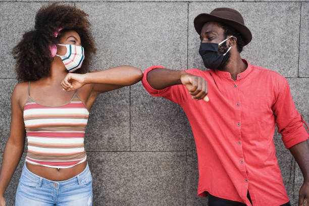 les africains portent des masques faciaux tout en se cognant les coudes au lieu de saluer avec des câlins - focus sur les visages - granite travel audio photos et images de collection