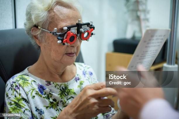 Senior Chinese Woman Checking Eyes Vision In Ophthalmological Clinic Stock Photo - Download Image Now