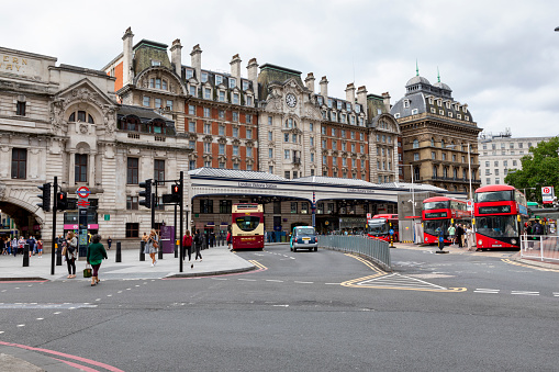 London, England - Aug 19,2021: Exterior view of Victoria railway station in central London. It has a traditional large glass roofed canopy outside the entrance.