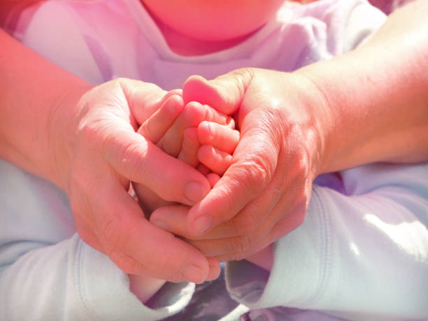 nonna e nipote che si tengono per mano insieme. - multi generation family adoption family human hand foto e immagini stock