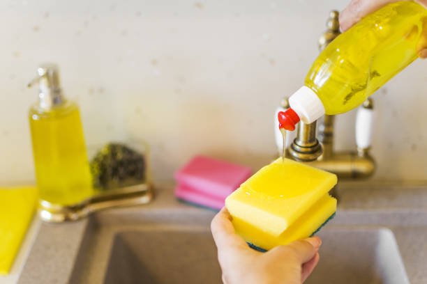 dishwashing liquid with a sponge on kitchen sink - dishwashing detergent imagens e fotografias de stock