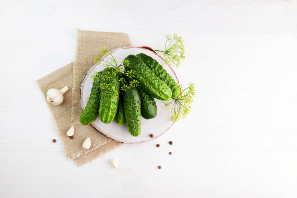 pepinos frescos com dill e alho em um fundo de madeira. ingredientes para picaretas. - relish jar condiment lid - fotografias e filmes do acervo